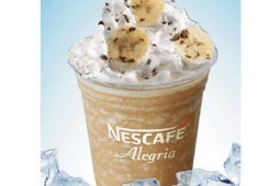 Vaso transparente con Cappuccino Vainilla de Plátano elaborado con NESCAFÉ® y decorado con chantilly