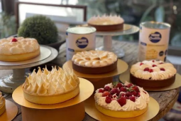 5 diferentes pies de fruta con crema montada sobre mesas de moldeado, elaborados con LA LECHERA®