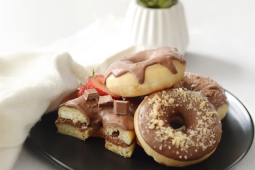 Cuatro donuts bañadas en KitKat spread sobre plato negro