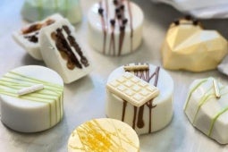 7 Alfajores de galleta con Manjar NESTLÉ® decorados de forma diferente sobre una mesa