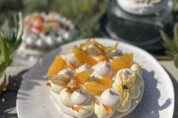 Torta de merengue suizo decorada con frutos amarillos y rellena con Manjar NESTLÉ®