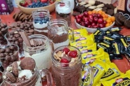 Vasos con diferentes tipos de postres para sorprender, y chocolates y toppings de NESTLÉ®