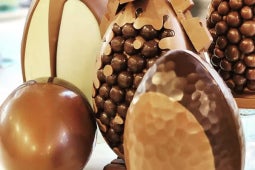 Huevos de Pascua rellenos con acabado brillante y decorados con productos NESTLÉ®