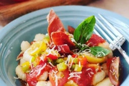 Ñoquis con salsa de tomates, cherry frescos, jamón crujiente, albahaca y queso rallado.