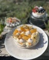 Torta de merengue decorada con gajos de naranja y uchuvas