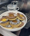 Bandeja con Galletas Linzer junto una taza blanca de Nescafé y una máquina de café