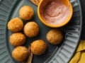 Plato con croquetas de papa redondas y una salsa elaborados con Productos MAGGI®