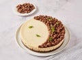 Cheese de queso con la mitad cubierta de racimos de chocolate, adornada con hojas de menta.