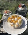Torta de merengue suizo decorada con frutos amarillos y rellena con Manjar NESTLÉ®