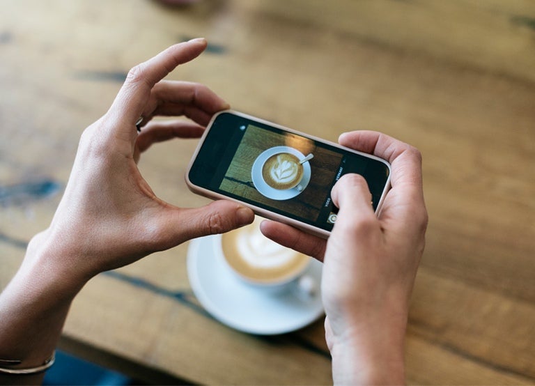 Persona toma foto con su smartphone para el plan de marketing gastronómico de su cafetería