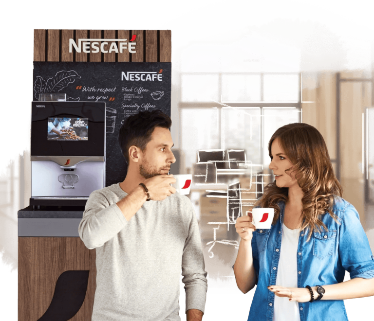 Pareja bebe café y al fondo una máquina NESCAFÉ®