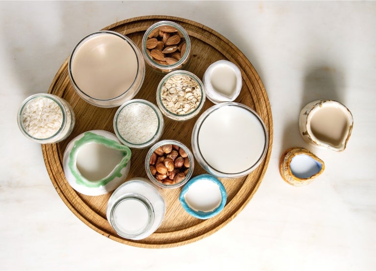 Bebidas vegetales de coco, avena, avellanas, almendras y arroz y recipientes con estos ingredientes
