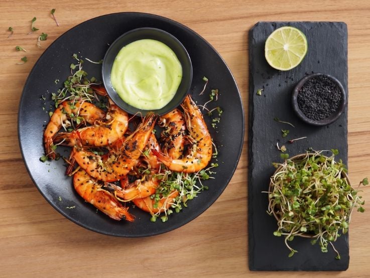 Tostada con camarones en salsa roja, acompañada de queso desmoronado y vegetales frescos
