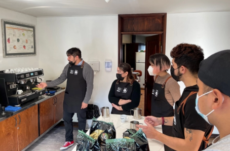 Grupo en capacitación práctica con máquina de espresso durante formación NESTLÉ® Jóvenes Baristas